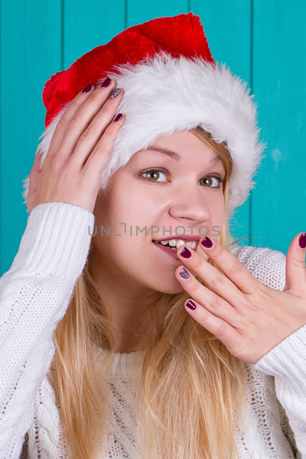 Beautiful woman in Christmas cap. blue background