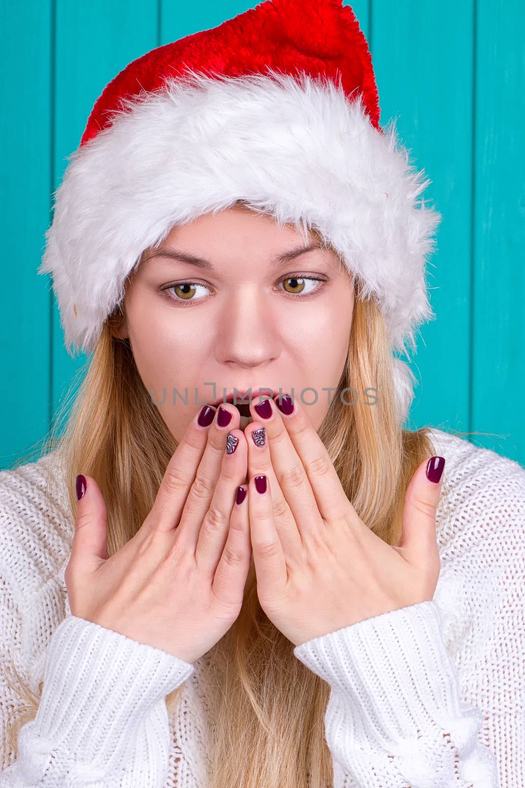 Christmas time. Young woman wearing santa claus hat red dress on blue background by victosha