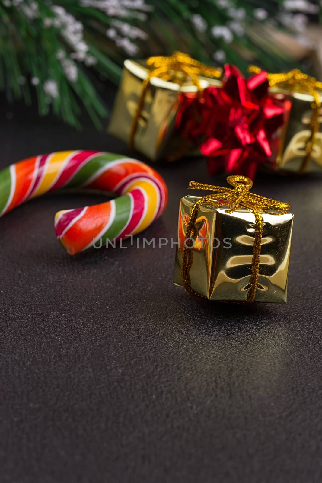 Christmas gift, tree branch and decorations on dark slate background. Christmas present background.