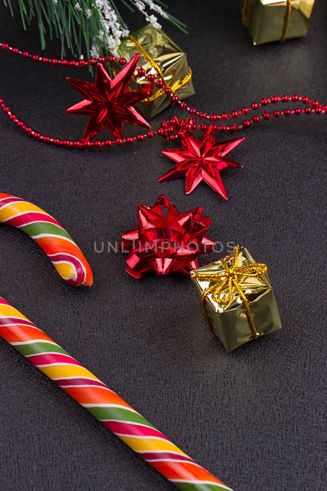 Christmas gift, tree branch and decorations on dark slate background. Christmas present background.