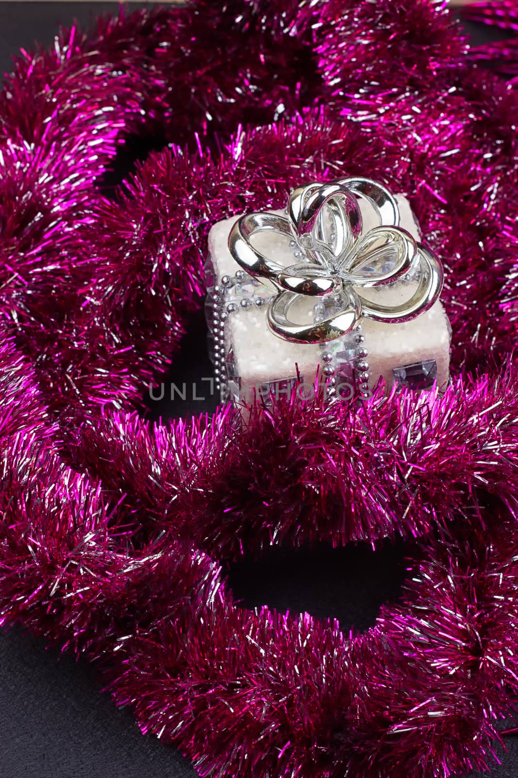 Christmas present with purple garland. a close-up
