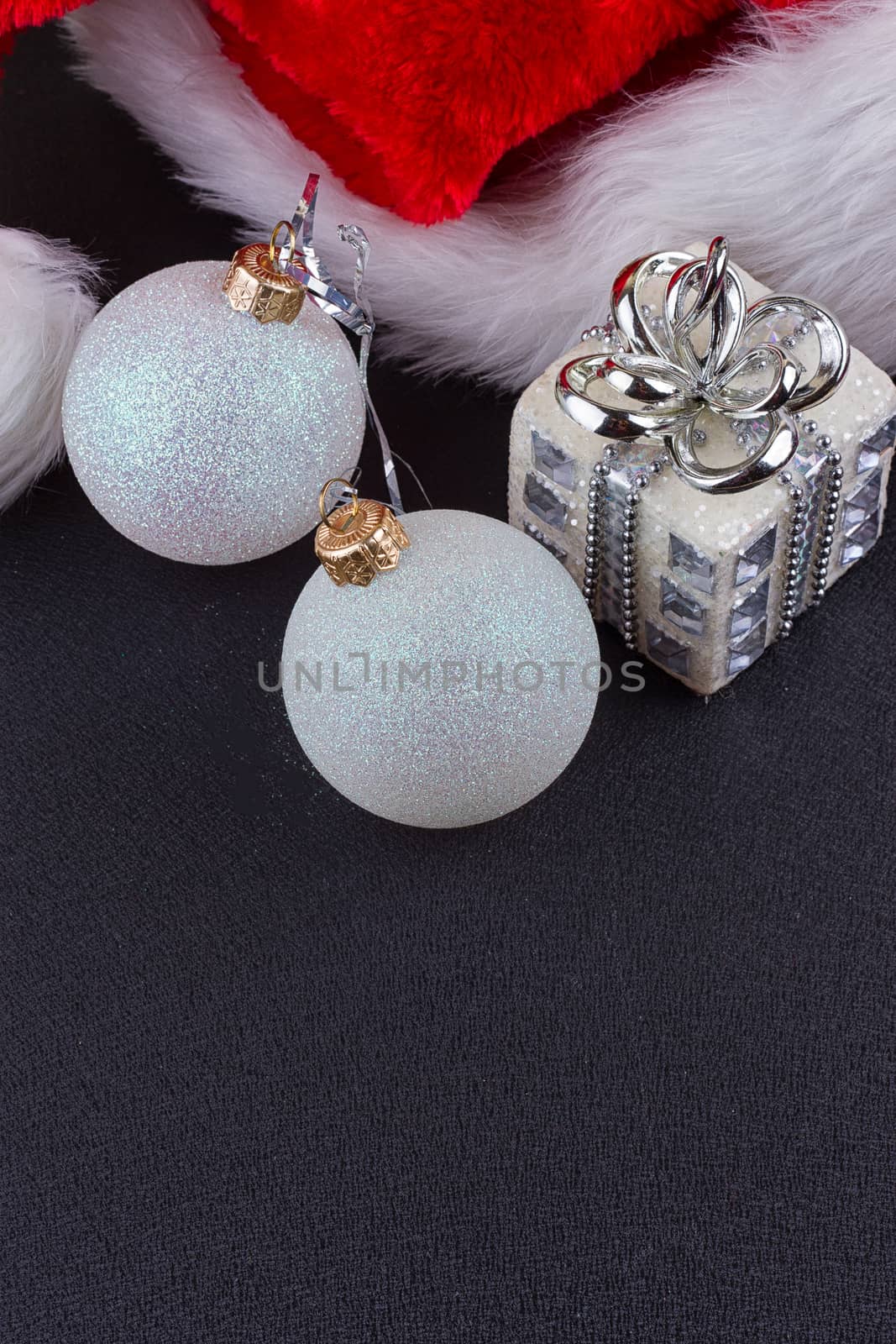 Christmas baubles and Santa hat, black background