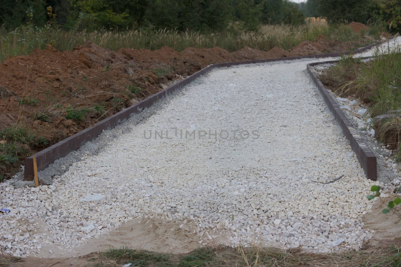 incomplete road with white gravel  in the forest