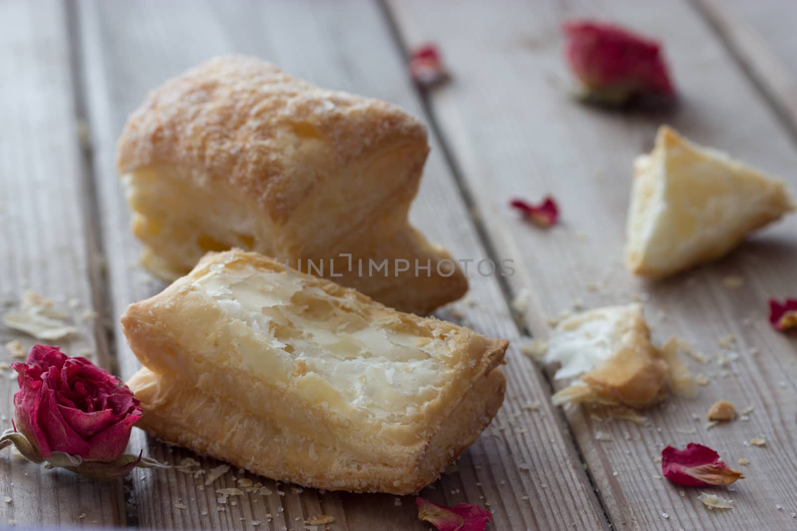 tasty cookies with dry roses on wooden table