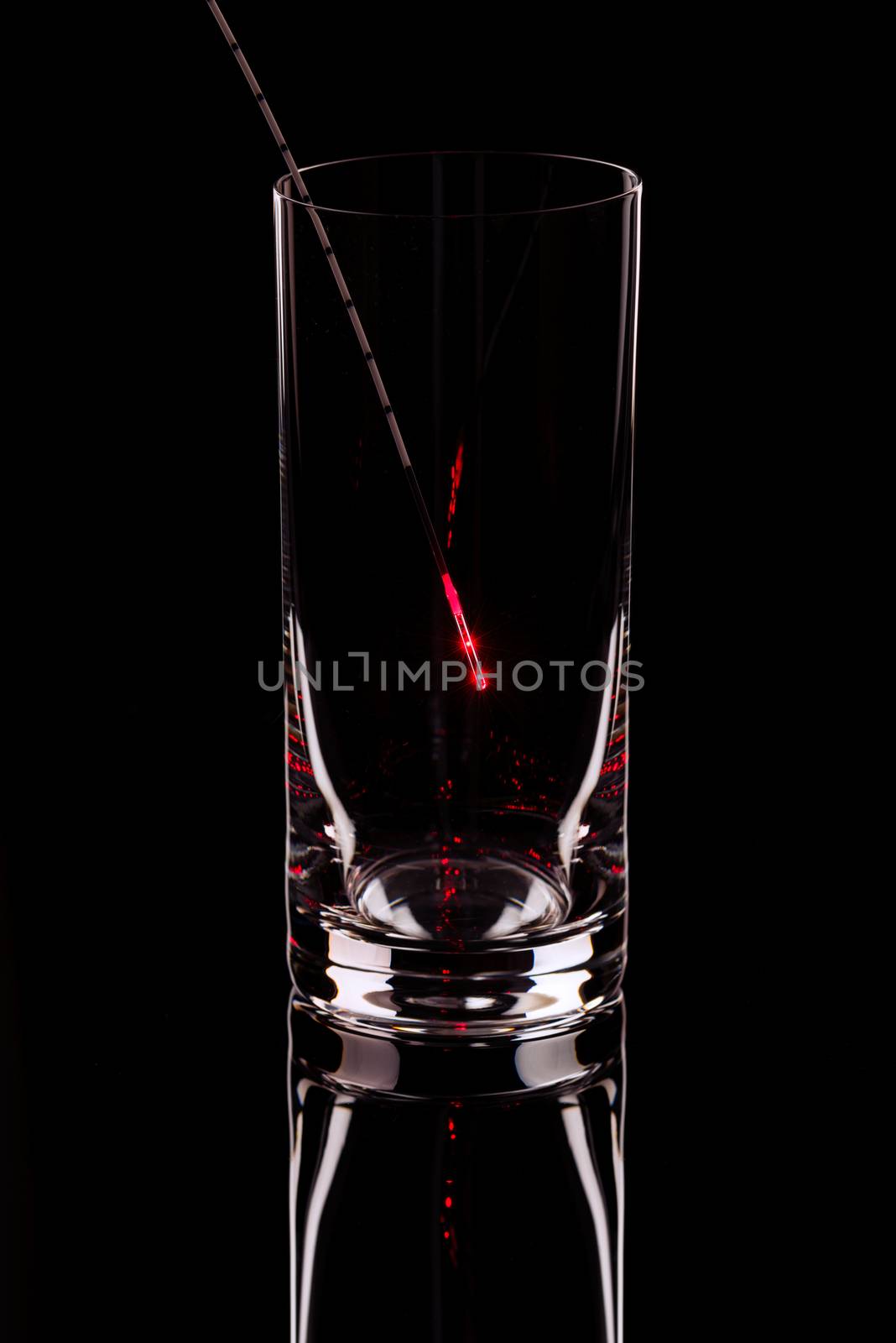 The shining probe in an empty glass on a black background