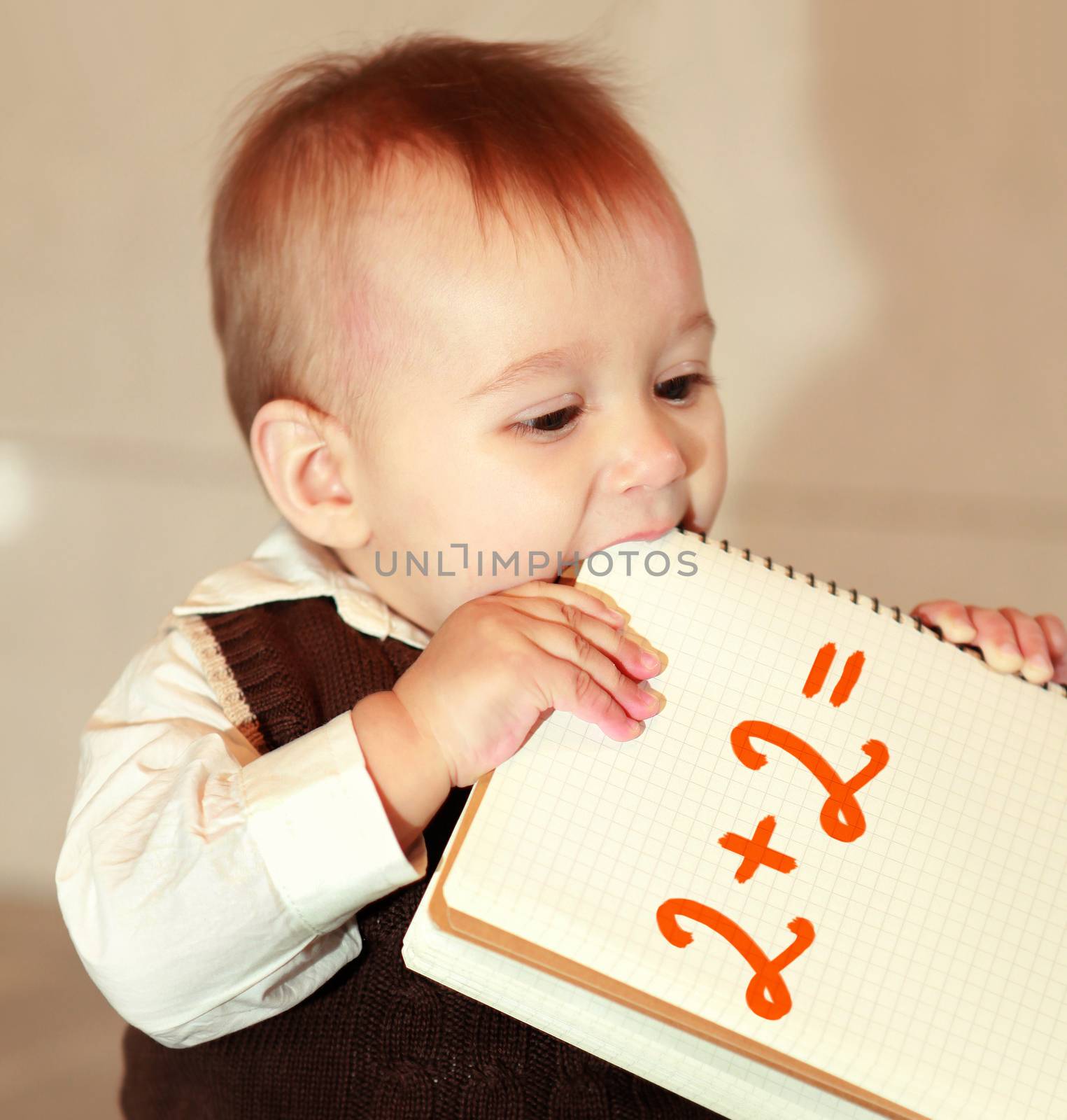 little boy studies a notebook, learns surrounding objects