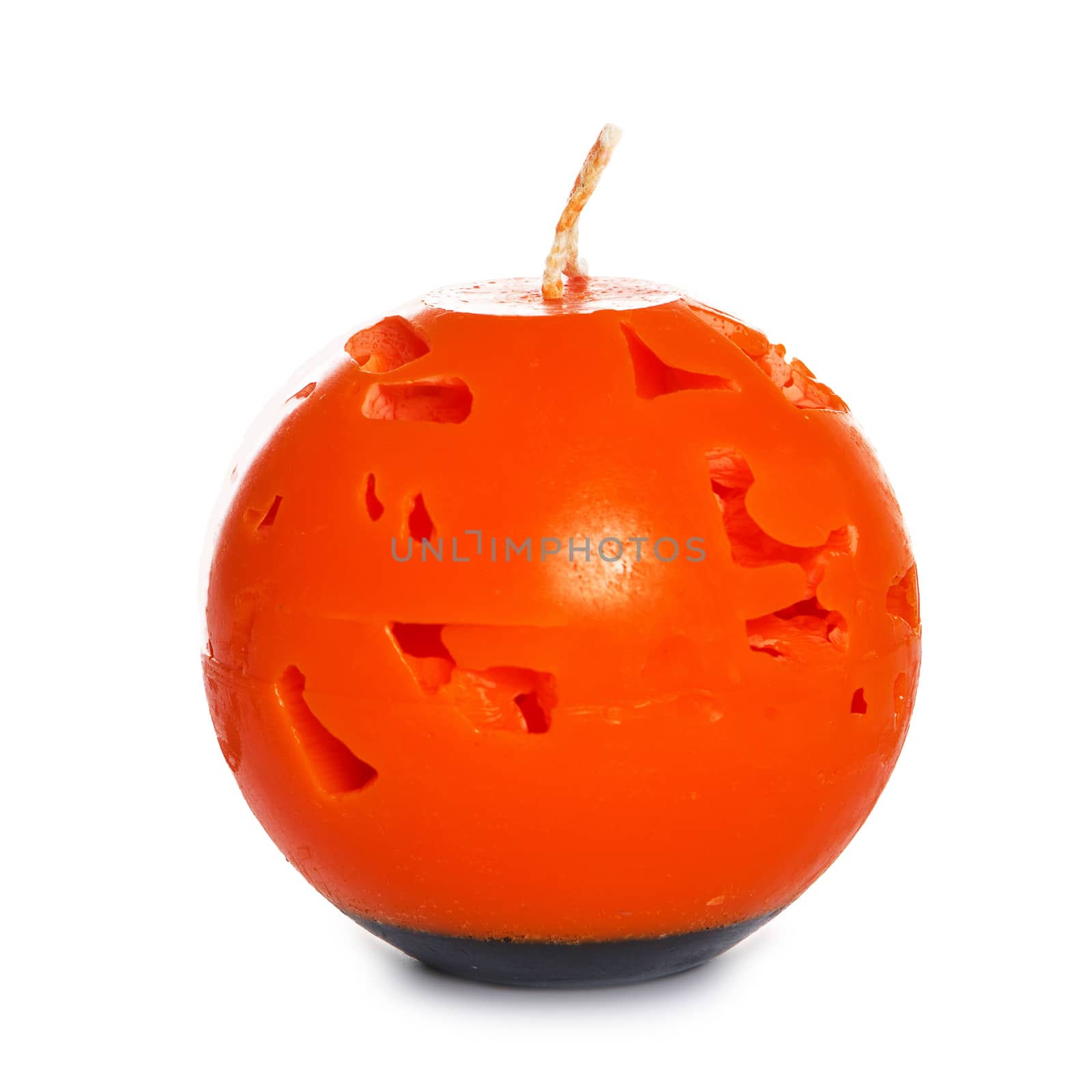 orange candle isolated on white background. Souvenir gift candle in the shape of Carved pumpkin. A burning sphere candle. Candle lit. Halloween