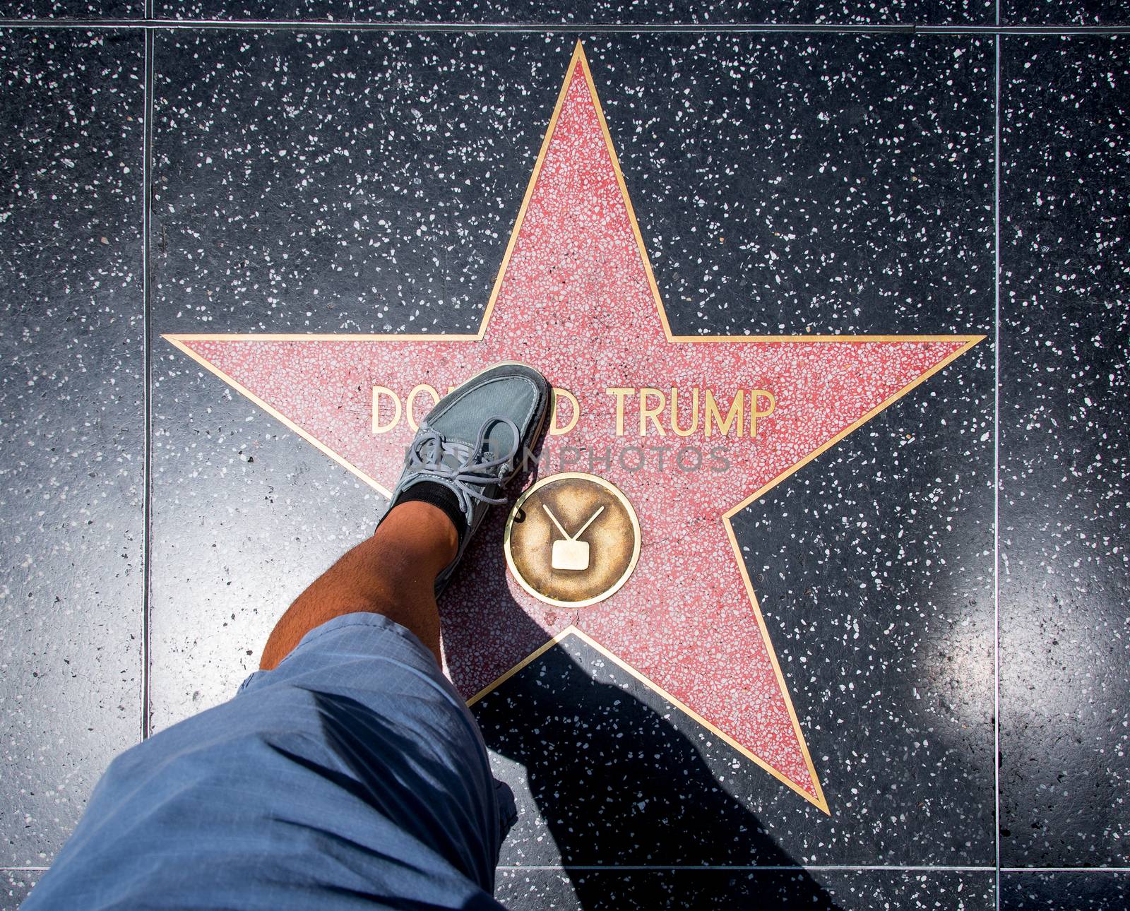 Los Angeles, USA - August 5, 2016: Man stepping on Donald Trump Star before it was damaged at Walk of Fame on Hollywood Boulevard, Los Angeles, on August 5th 2016.