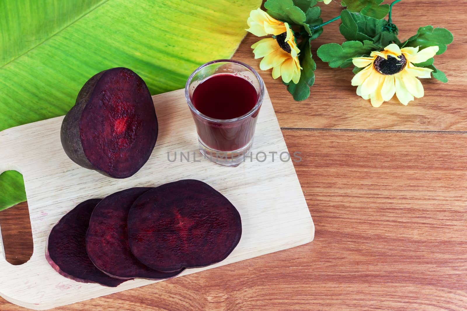 Fresh slices red beet root and beet root fruit juice in shot glass a wood background