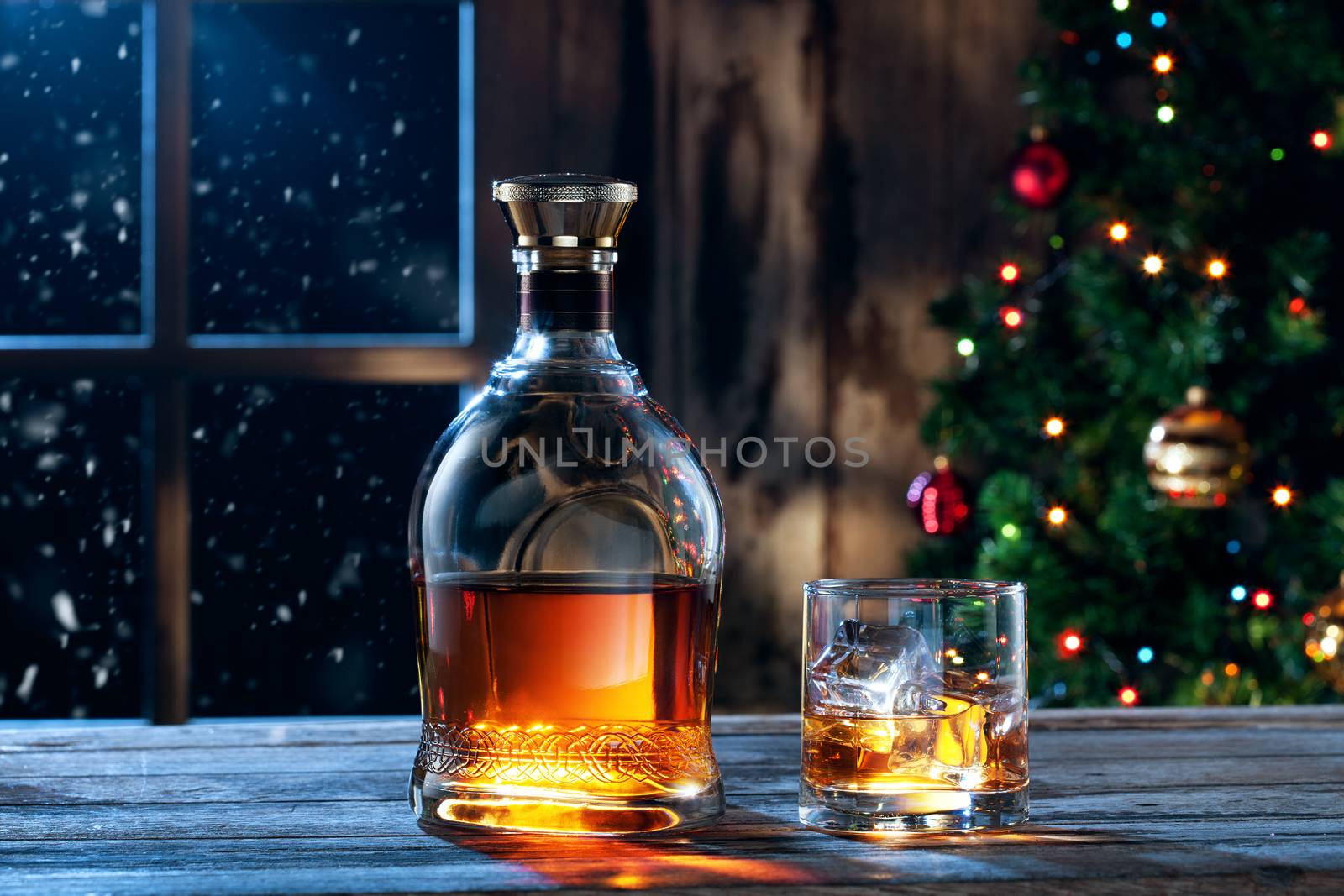 close up view  of glass  with whiskey and bottle  on color back
