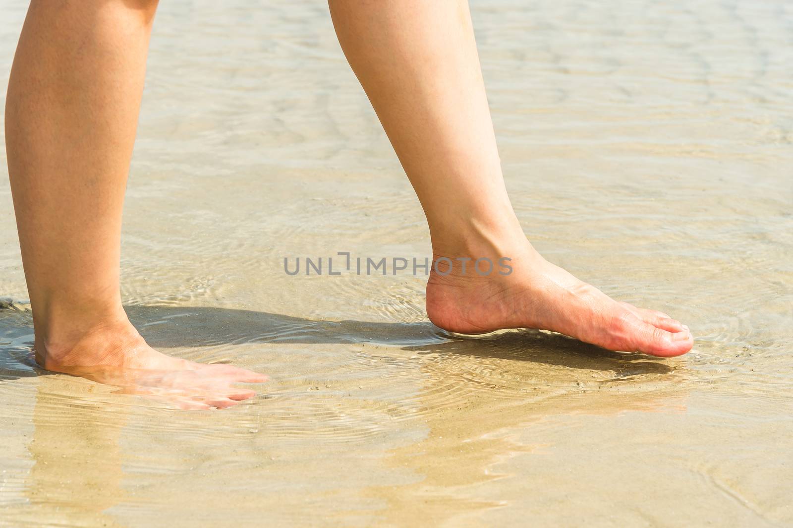 woman feet in water on beach