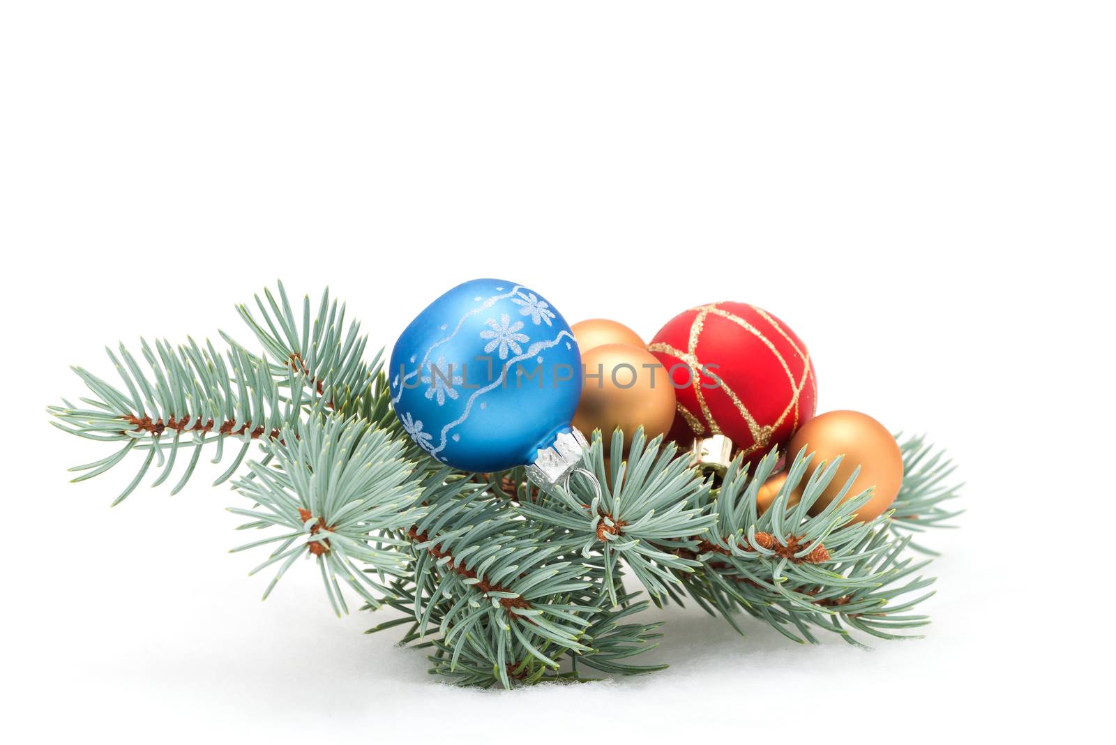 Colorful christmas baubles on a fresh spruce bough.