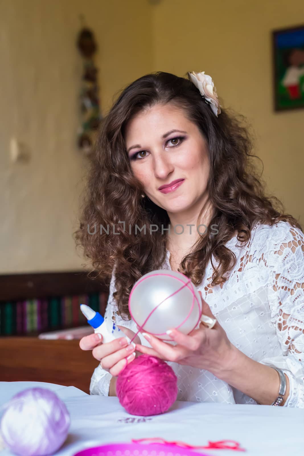 Girl doing decoration with balloons and colored threads