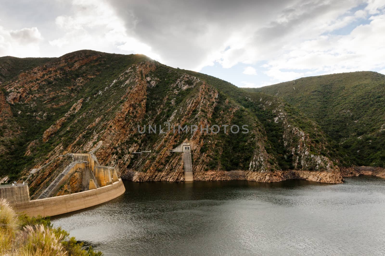 Low water level at the Kouga Dam with storm clouds approaching.
