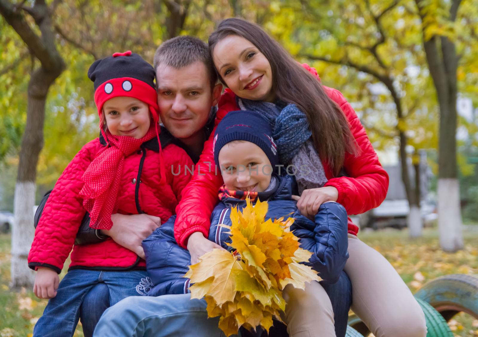 Happy family with two children in autumn park