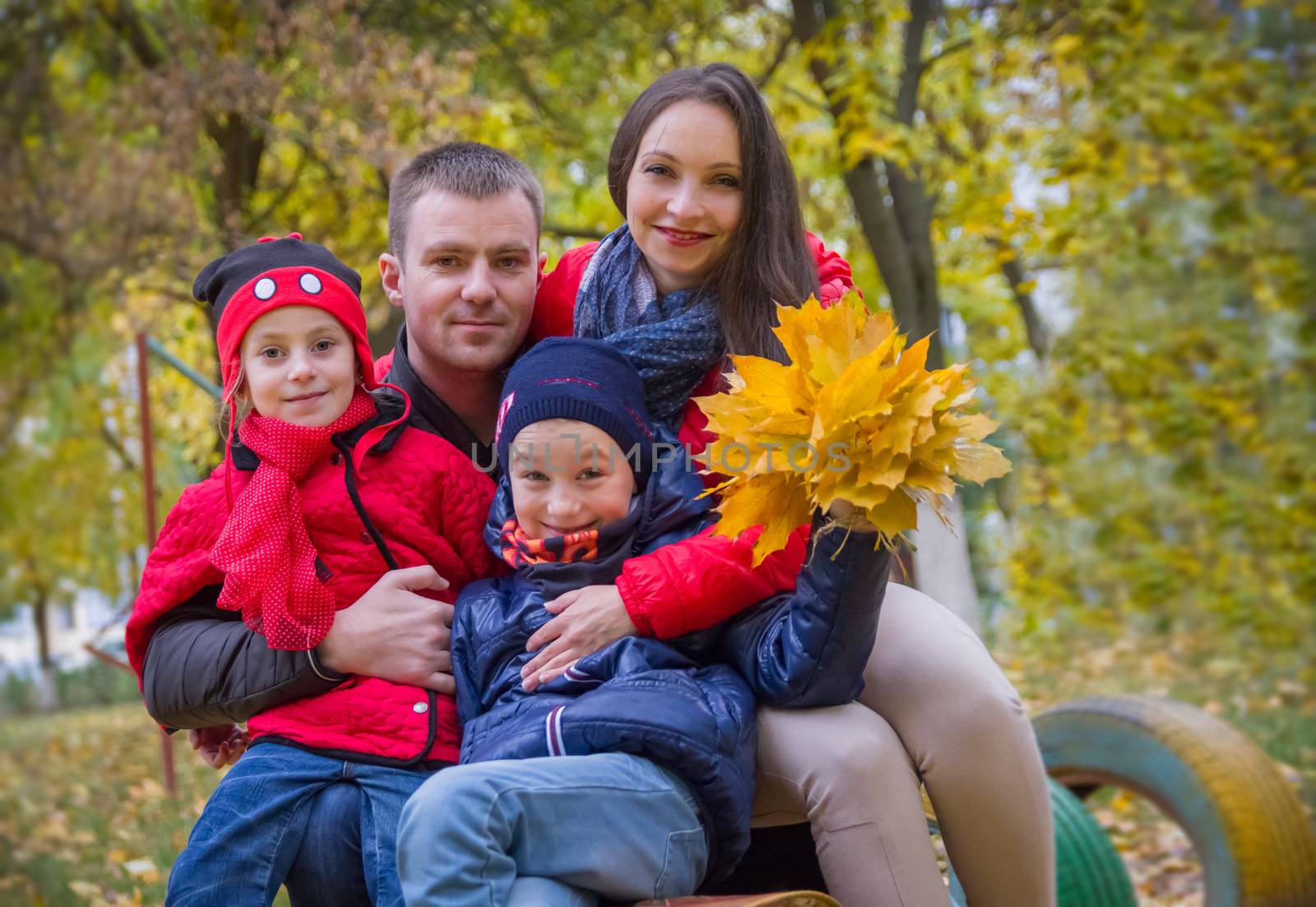 Happy family with two children in autumn park