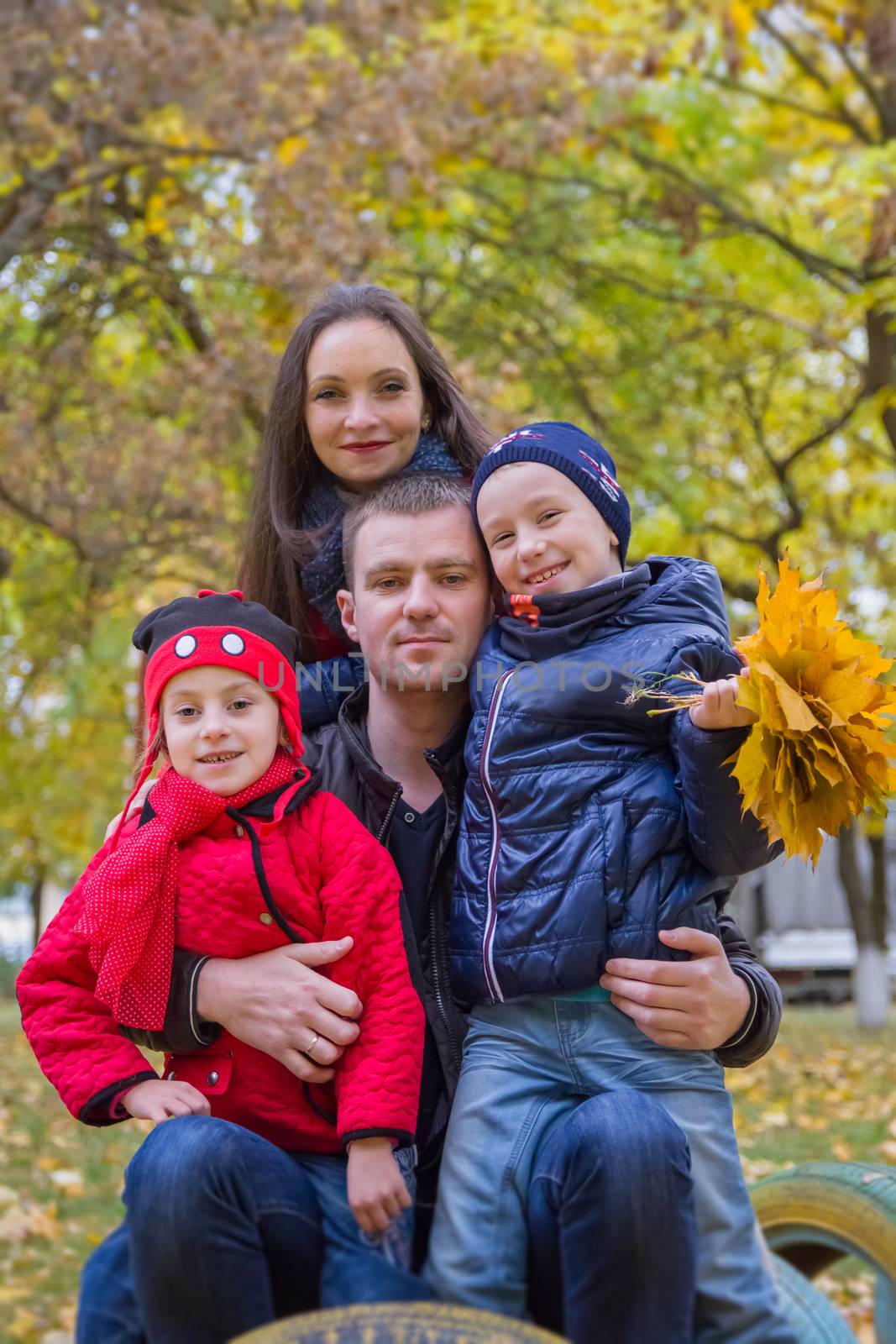 Happy family with two children in autumn park