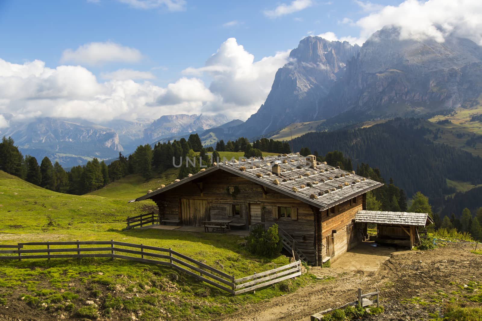 View of a mountain hut on a sunny day with mountains in the background