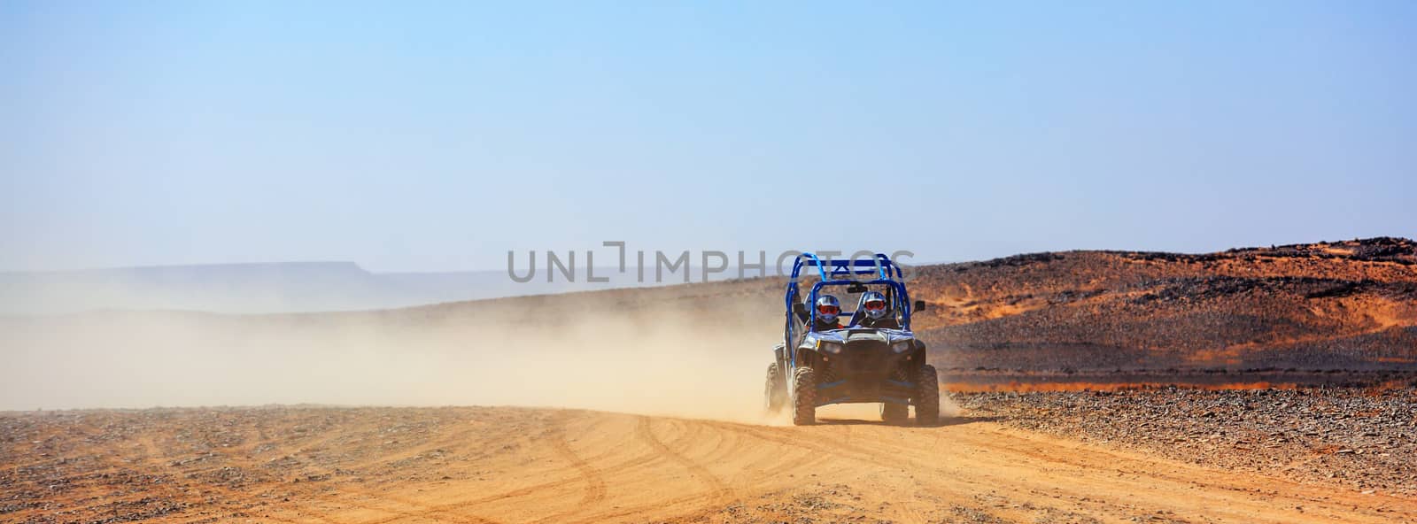 panoramic view on off road car with it's pilots in Morocco desert near Merzouga
