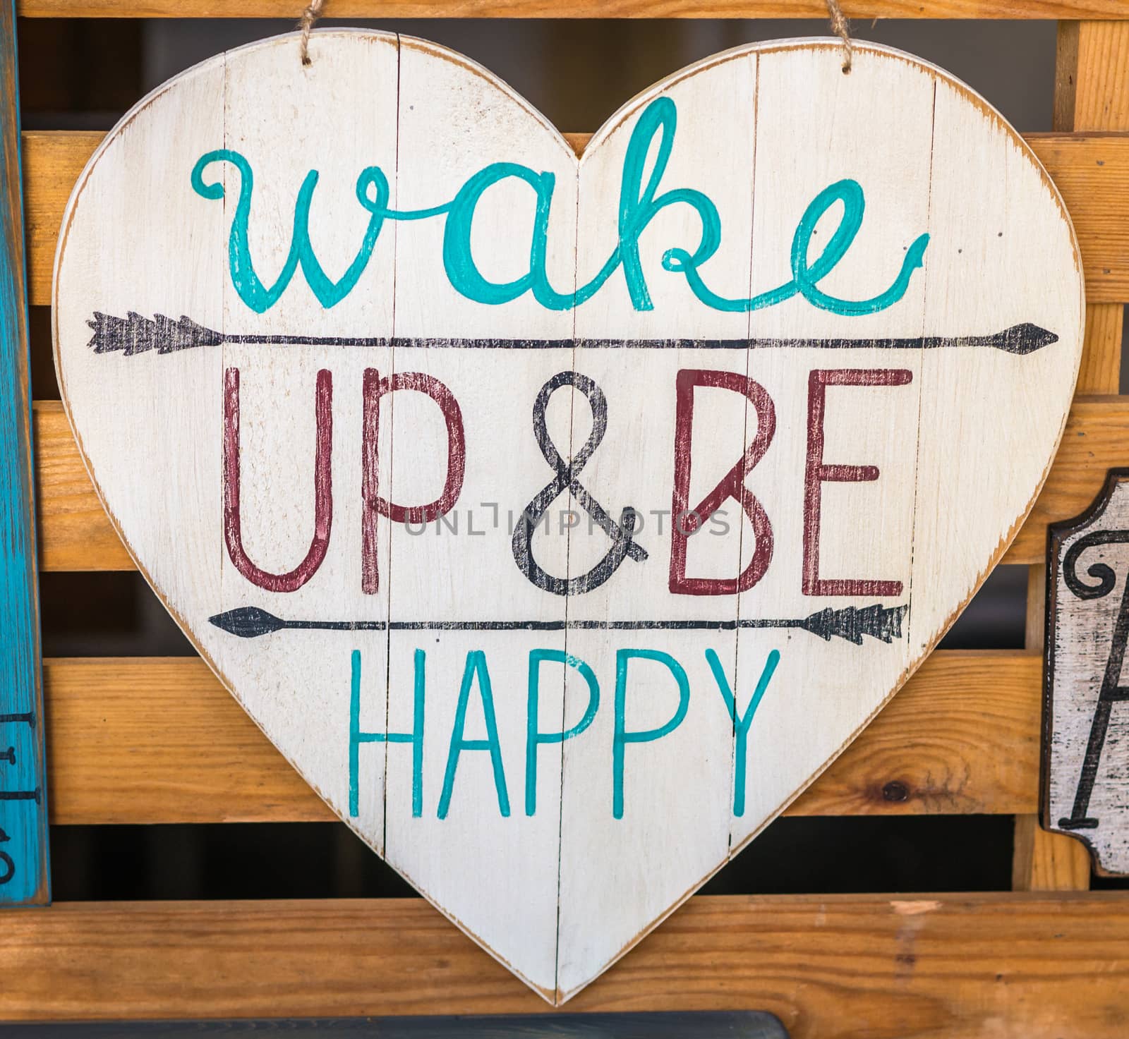 wooden board in the shape of a heart with the inscription 'Wake up and be happy'
