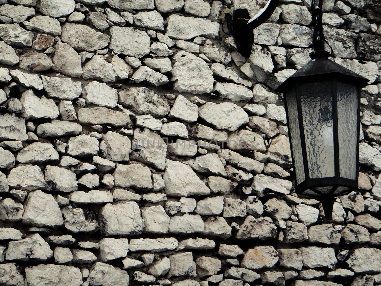 Old stone wall with lantern by natali_brill