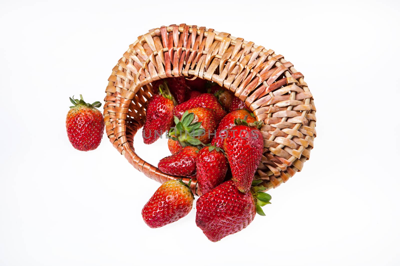 Wicker basket with strawberries on isolated background