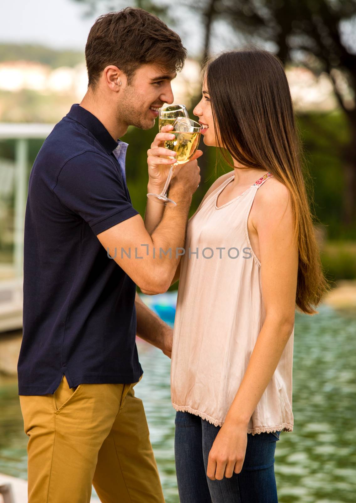 Young couple tasting wine near by the pool on a hotel