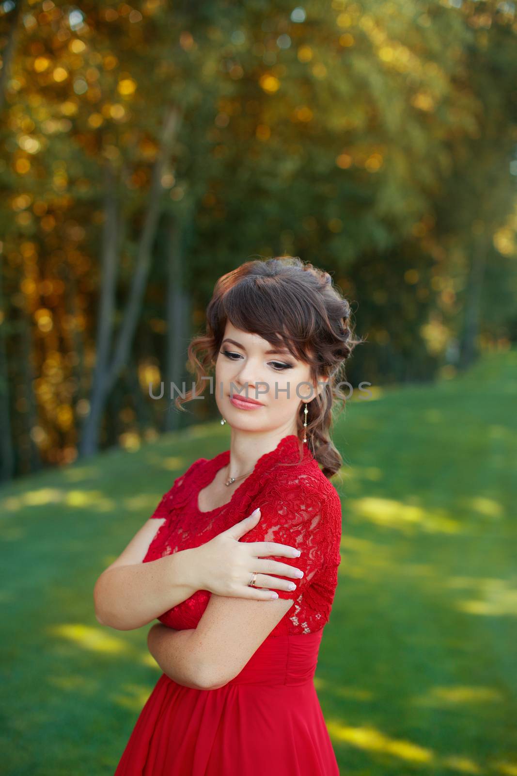 Girl in evening red dress in a warm summer day