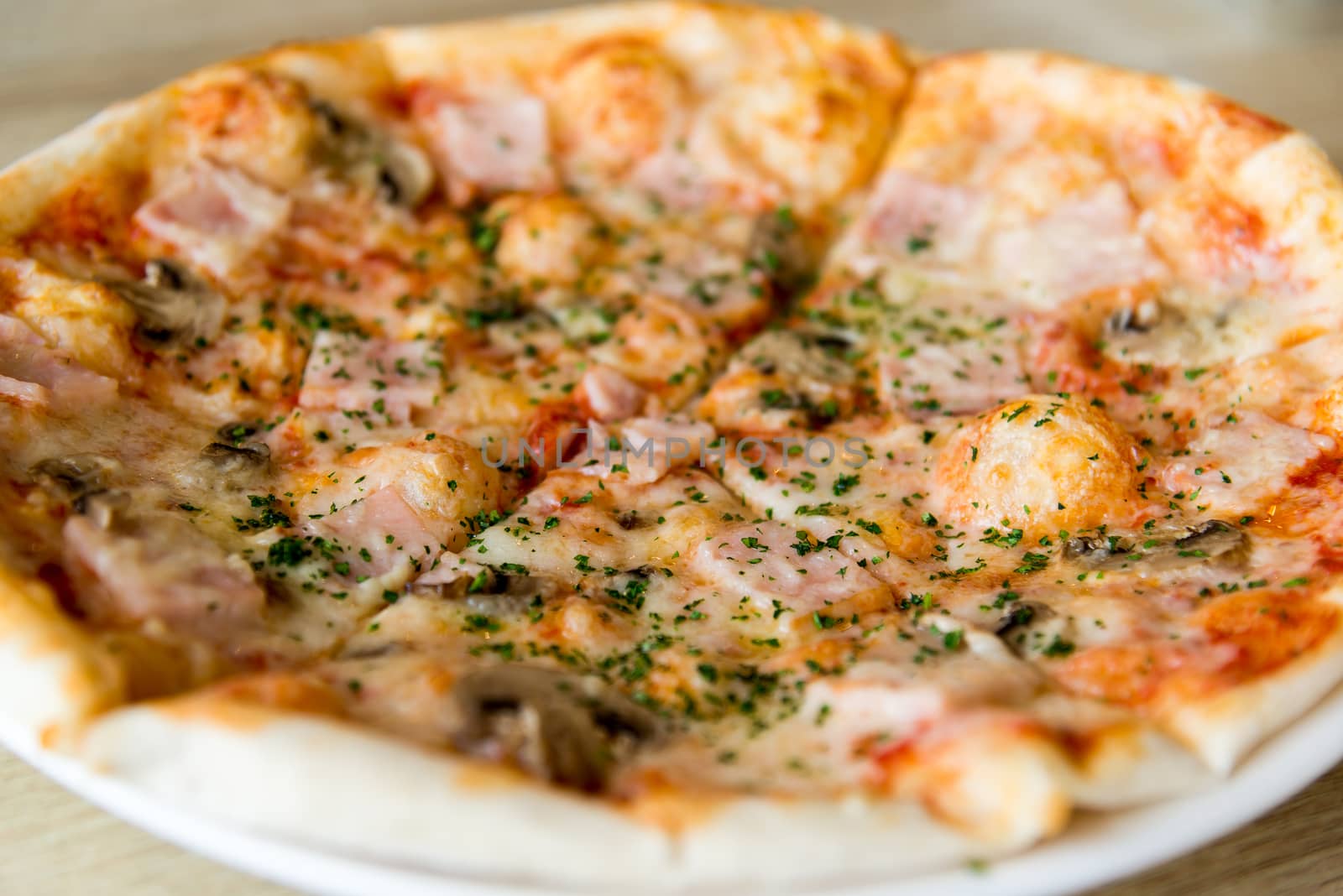 Pizza with mushrooms and ham on a plate