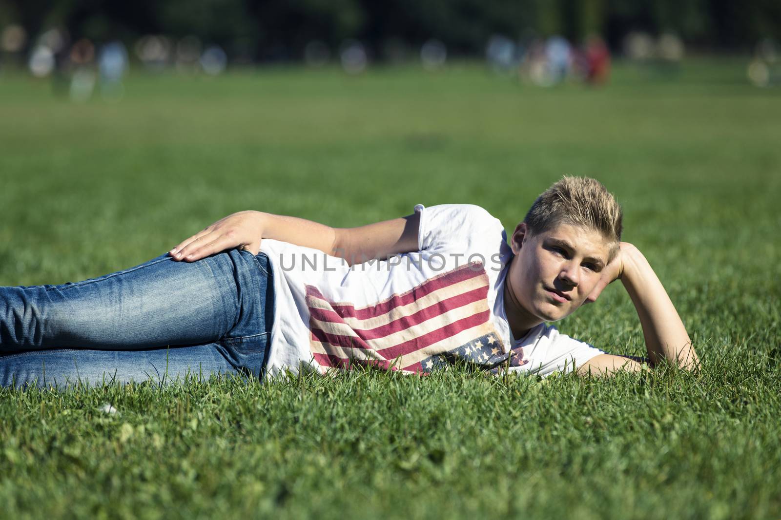 Portrait of a boy fourteen years of age lying in the grass