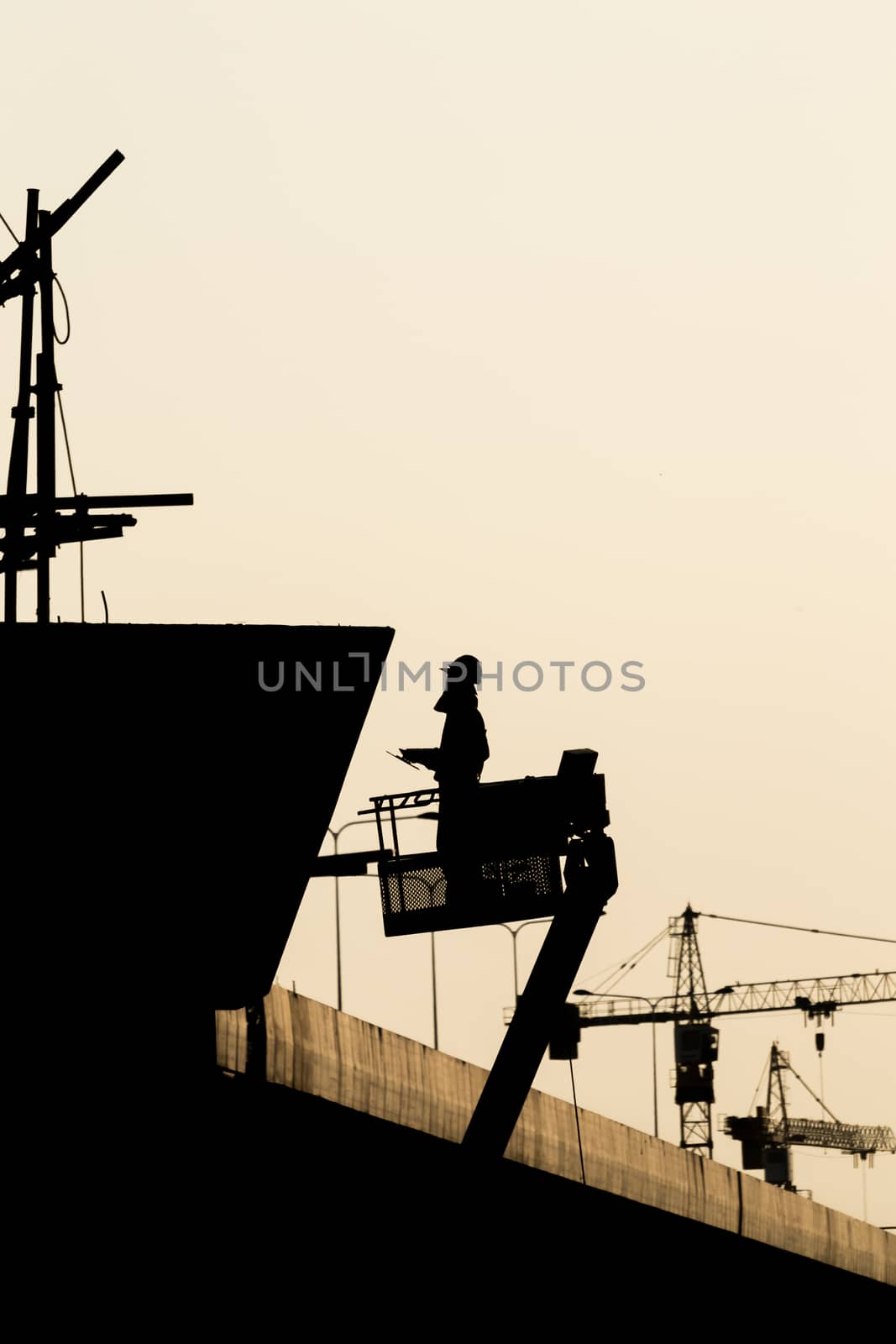 Silhouette of construction worker on scaffolding in the construc by Soranop01
