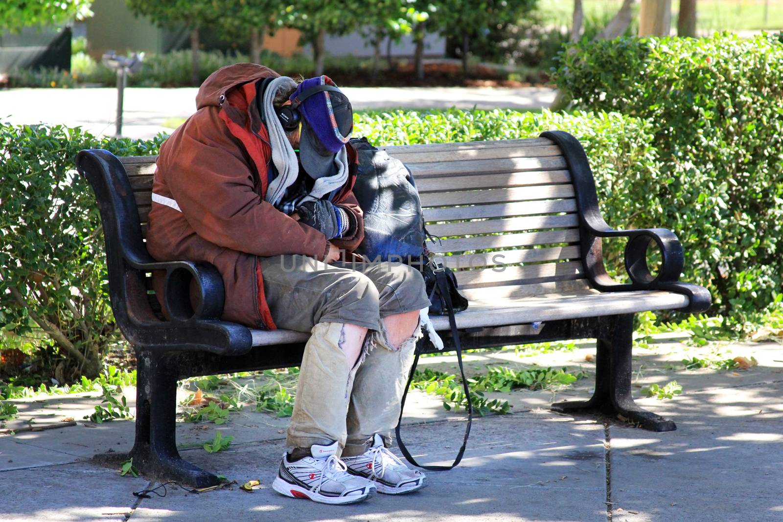 San Francisco, CA, USA - September 26, 2013: Homeless man sleeps on the street in the center of San Francisco