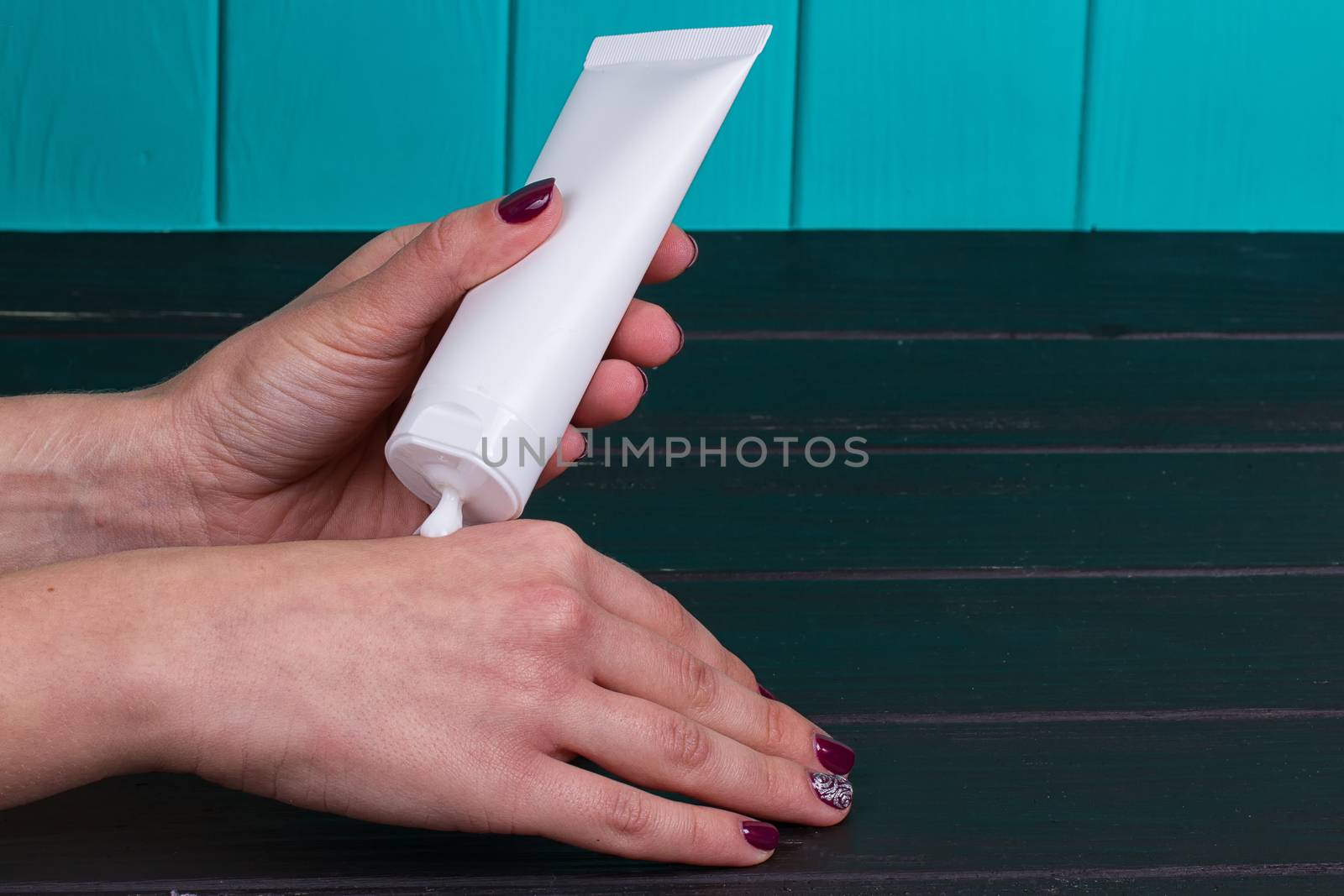 Female hand cream squeeze out of a tube