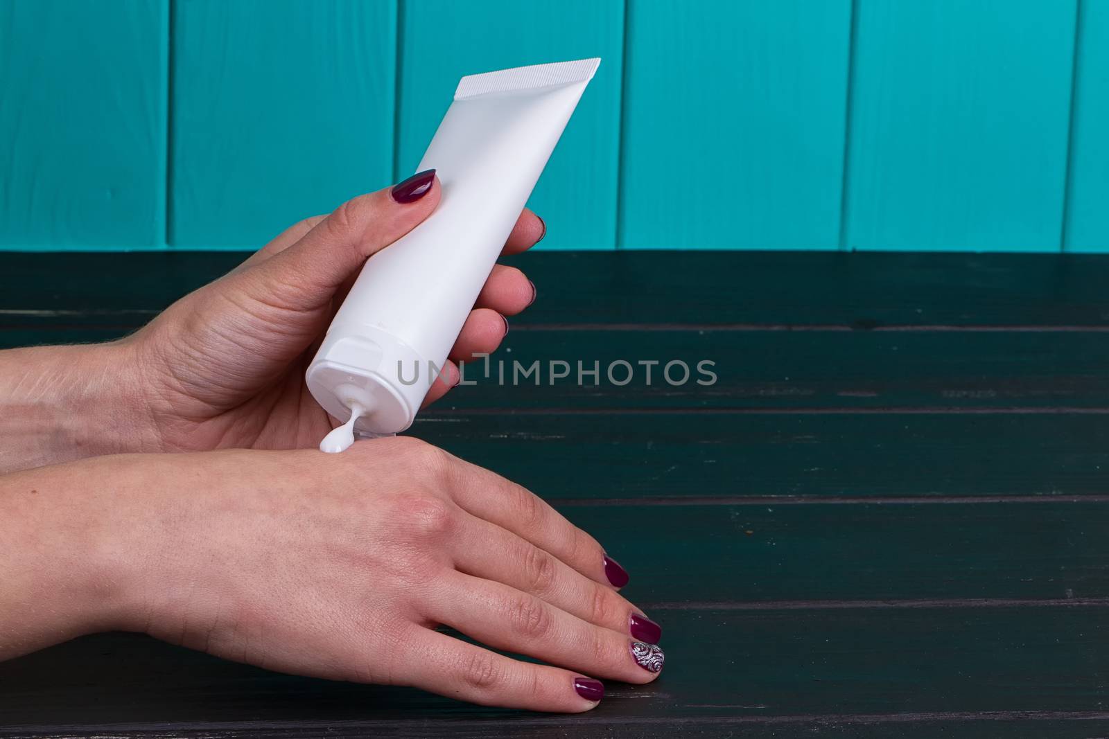 Female hand cream squeeze out of a tube