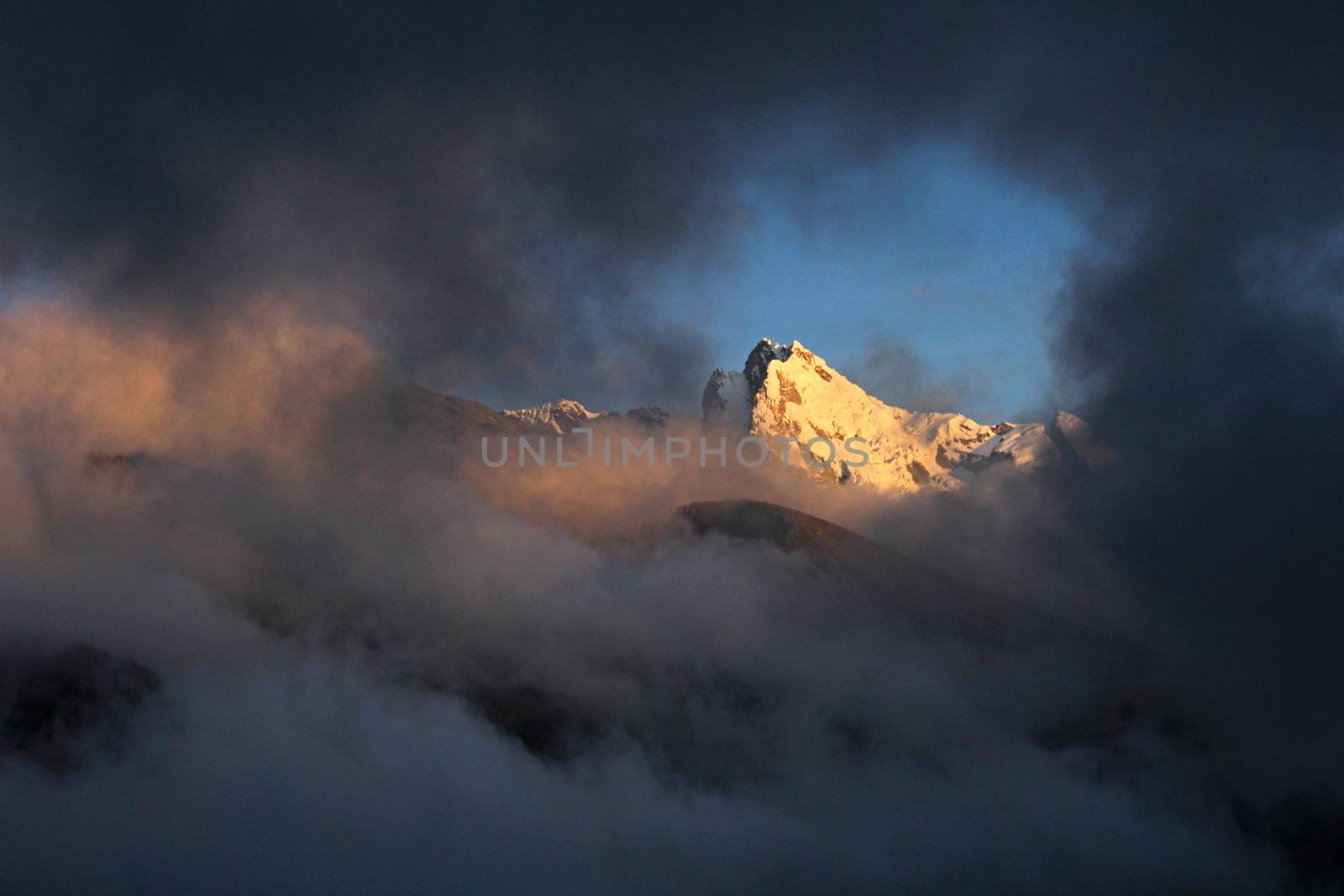 Huantsan mountain peak with clouds and late sun in the peruvian Cordillera Blanca