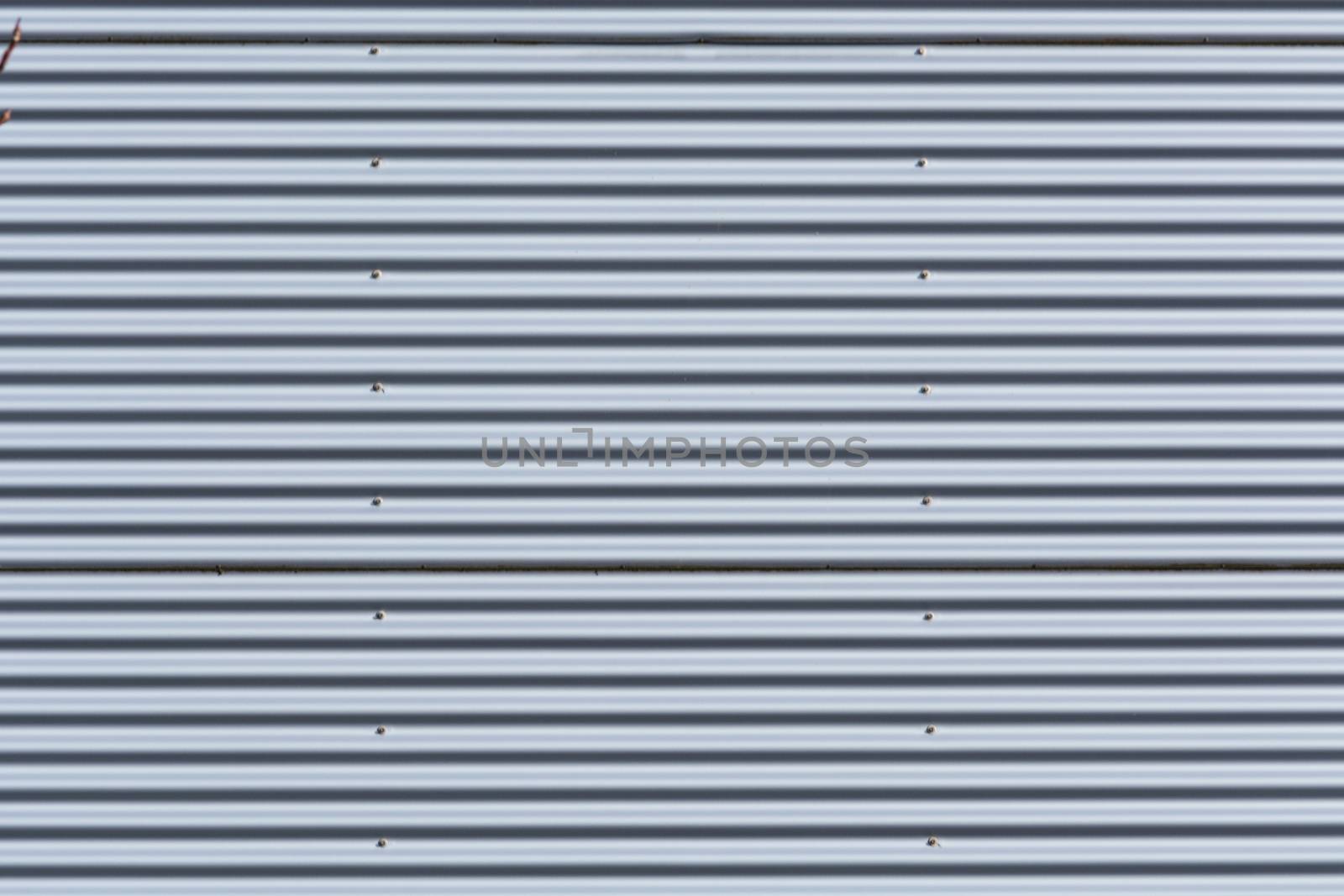 Silver-colored metal wall corrugated sheet metal background.