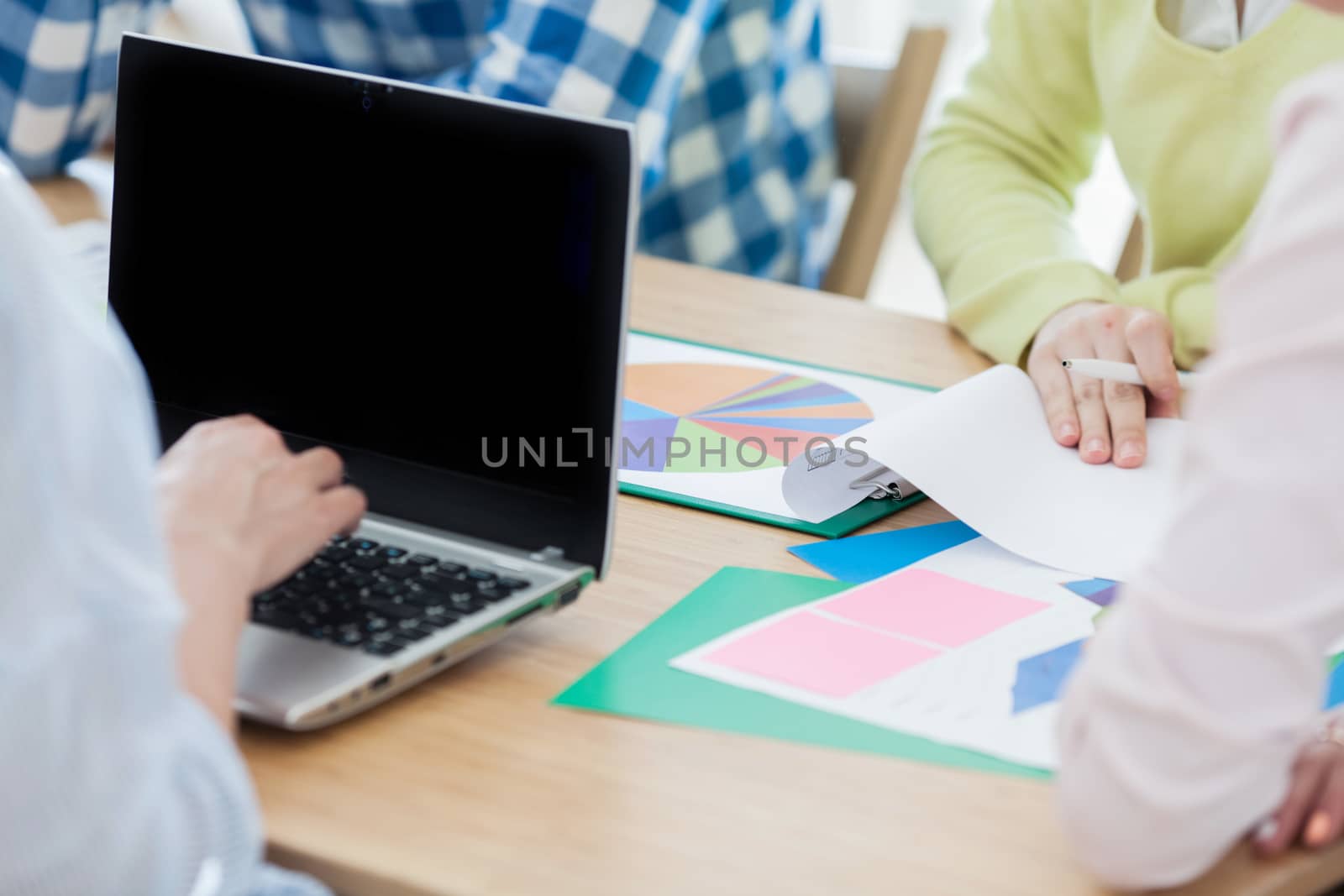Diverse people working with financial reports and laptop
