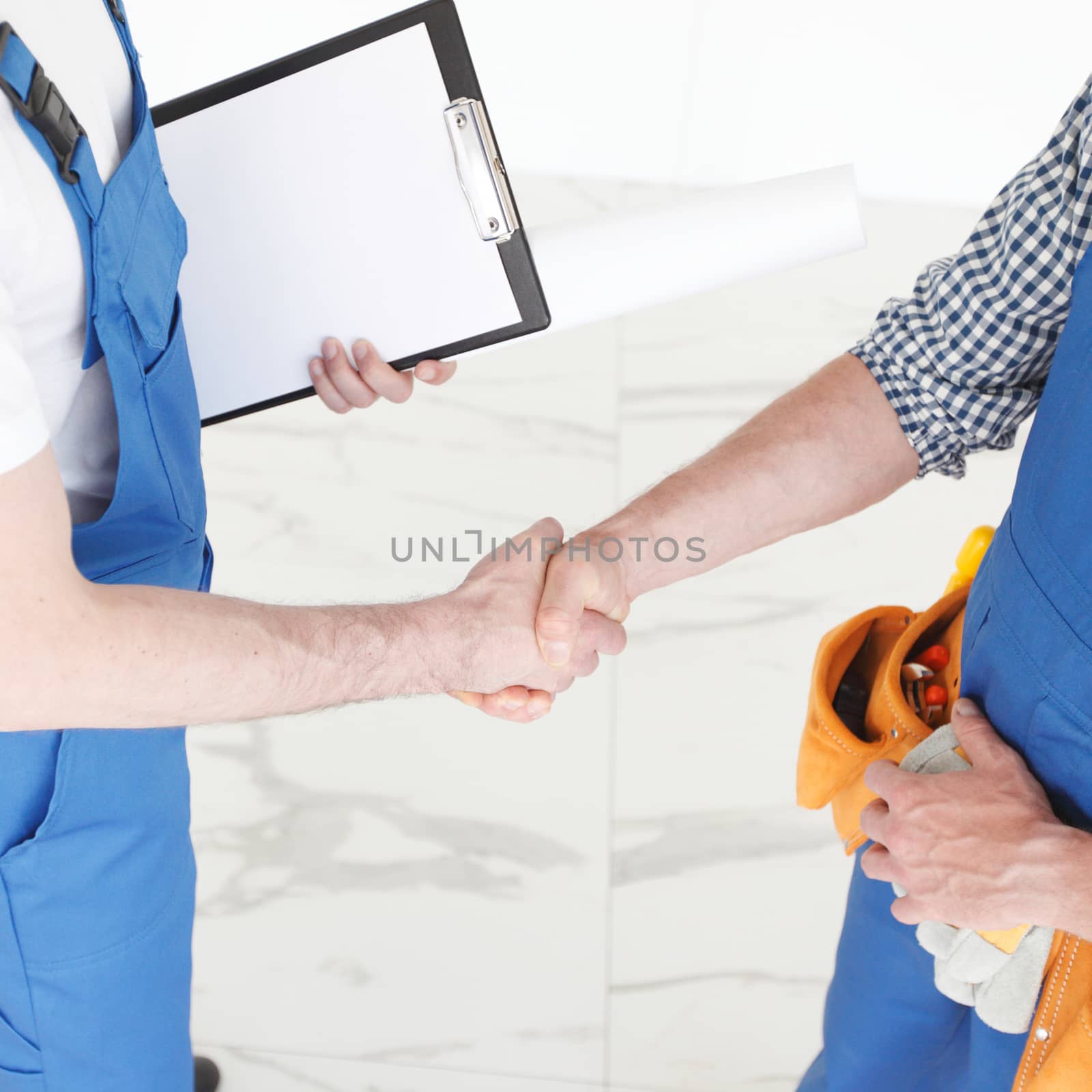 Two construction workers shaking hands, deal is finished concept