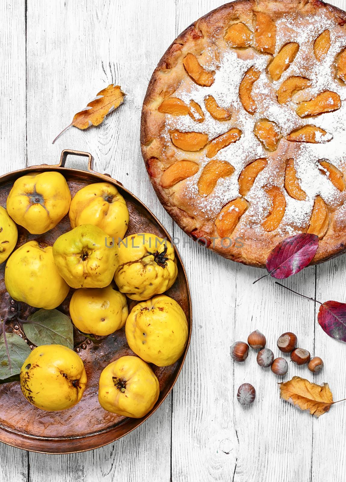 Cake with harvest autumn quince on light wooden background