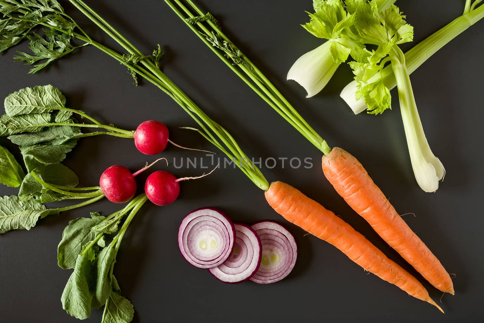 Fresh raw vegetables over a dark background seen from above