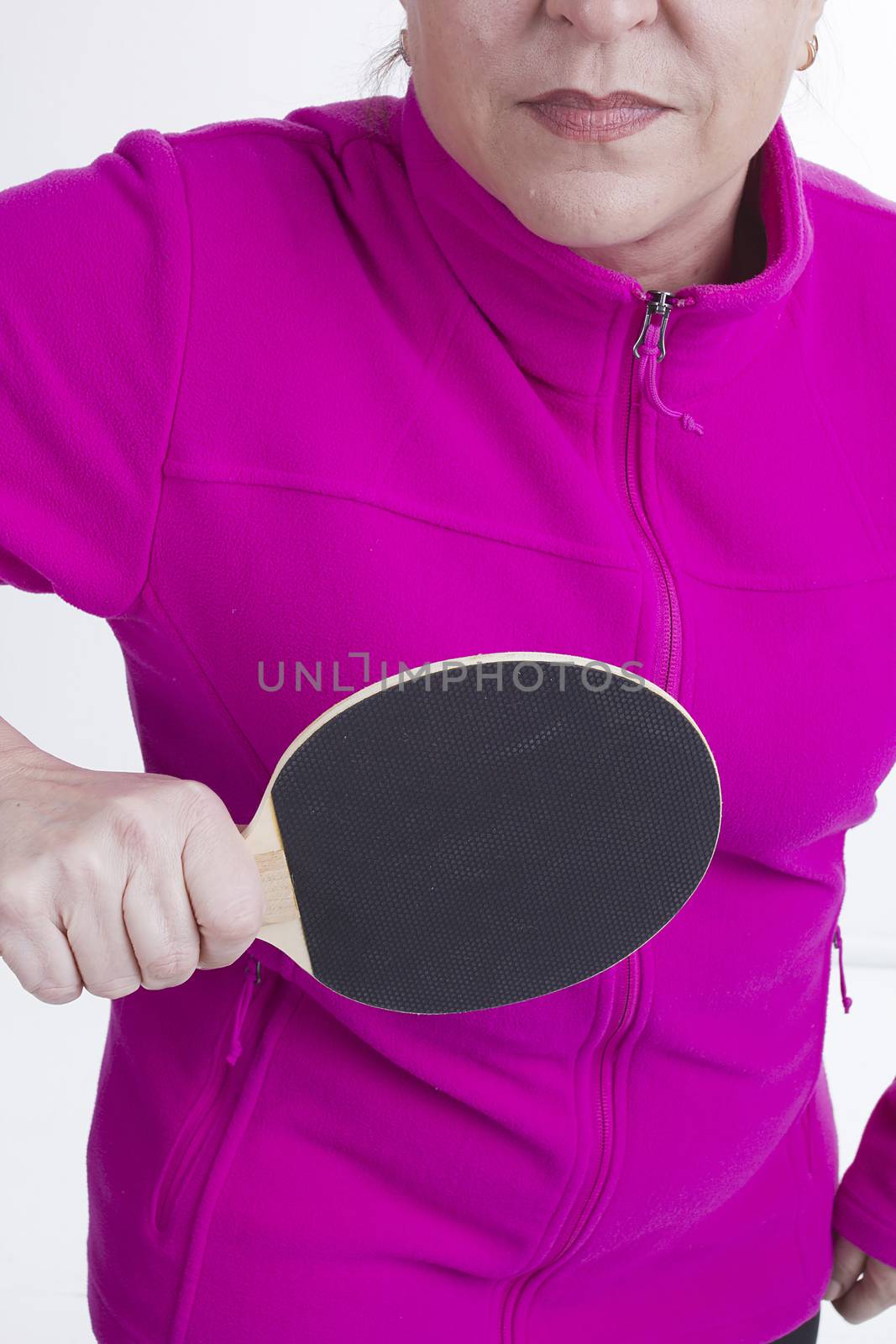 Active senior woman playing table tennis in front of white background
