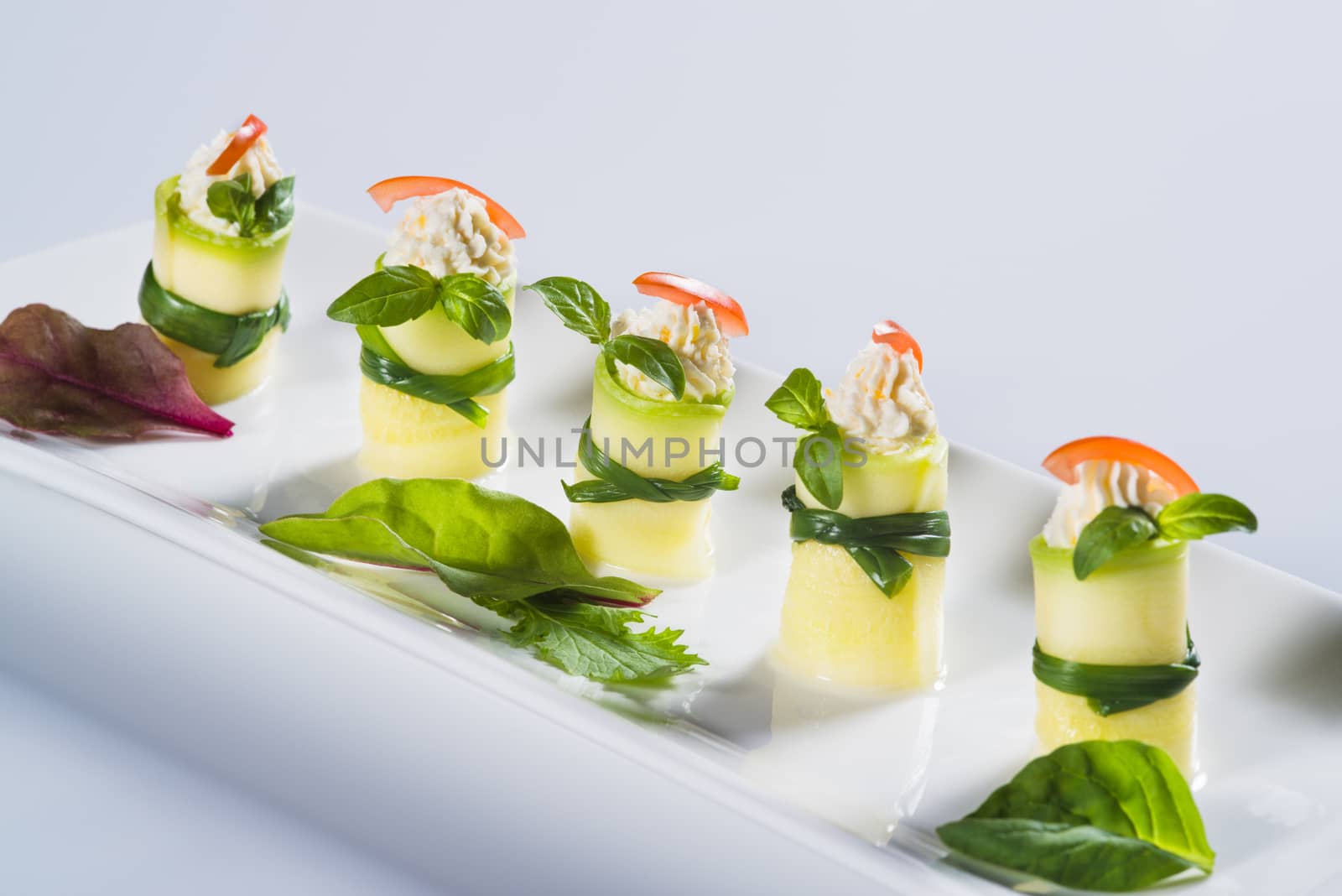 Fresh squash rolls with soft cheese on plate on light background by kzen