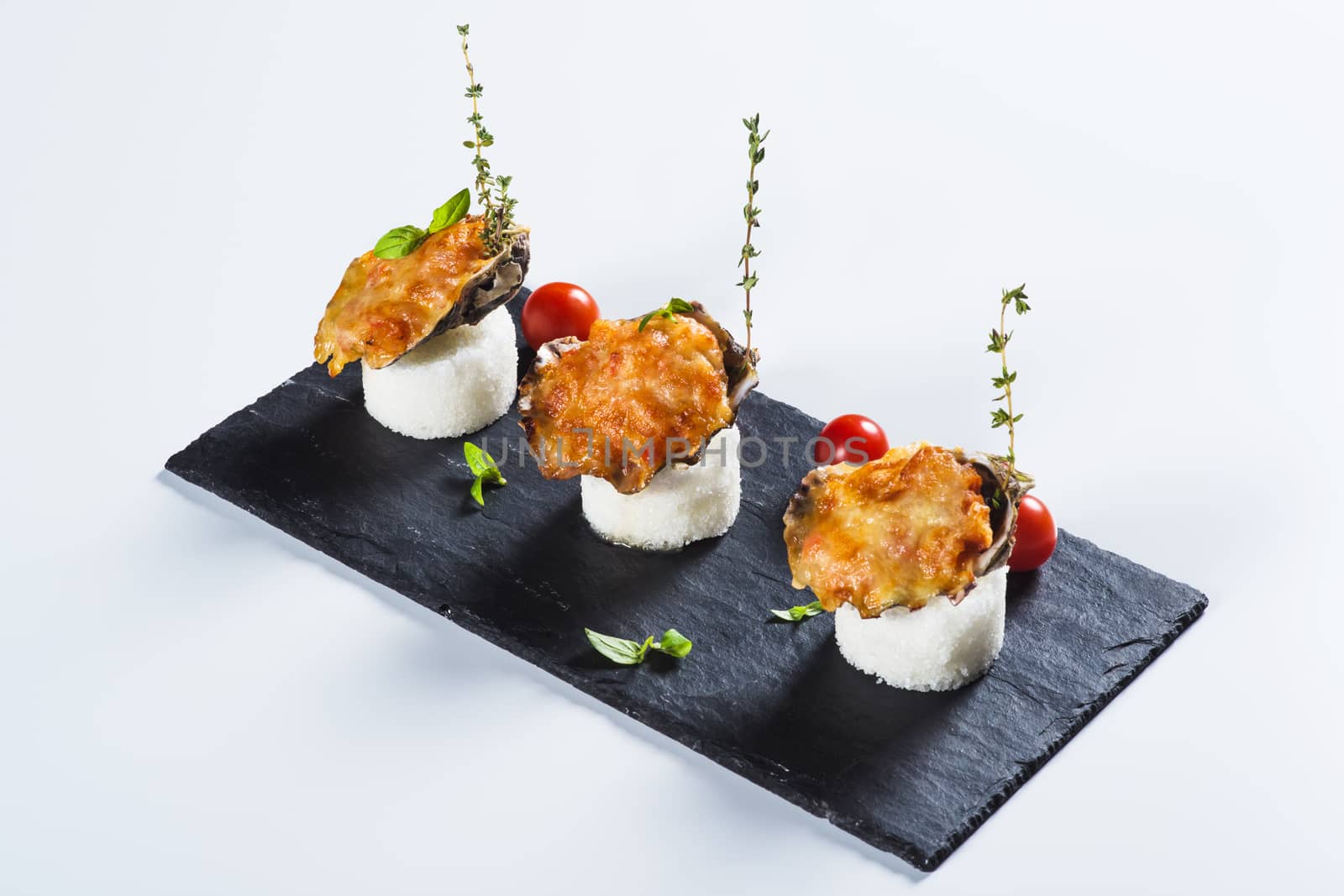 Beautifully decorated  baked oyster  with cheese on plate on  light background