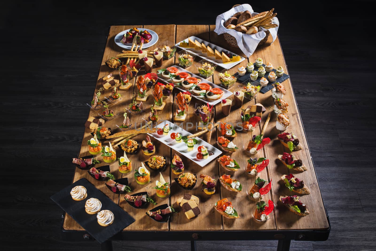 Snacks set. Brushettas, canapes, salads, desserts, tartlets, oysters on wooden table wooden background