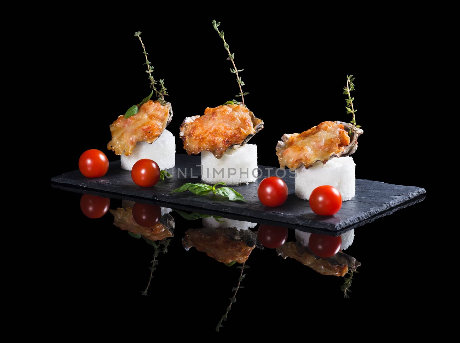 Beautifully decorated  baked oyster with cheese on plate on black background