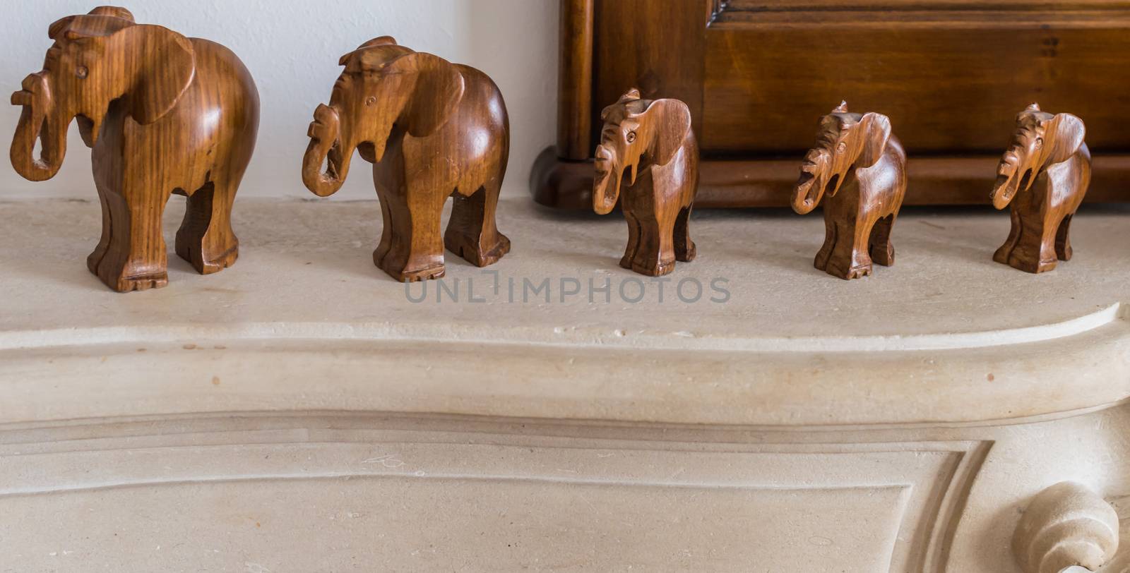 Carved wooden elephants on a marble pedestal in the room