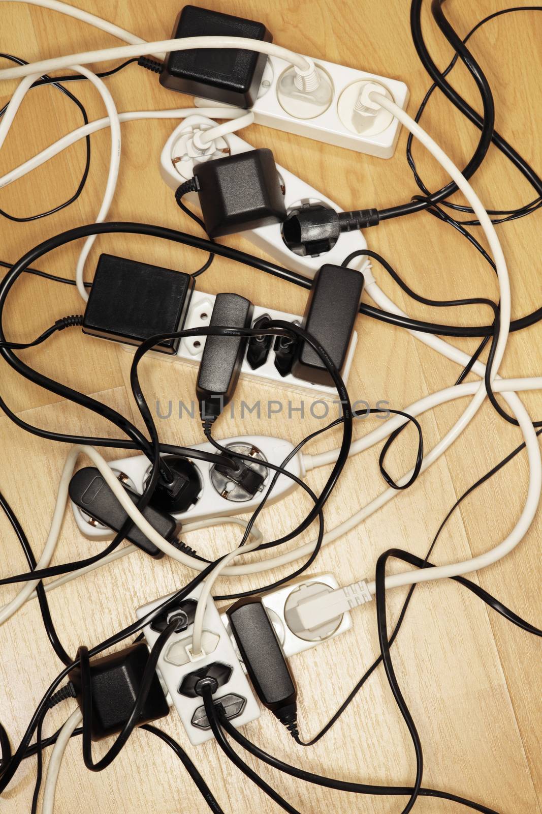 Cables and power adaptors connected to european extension cords.