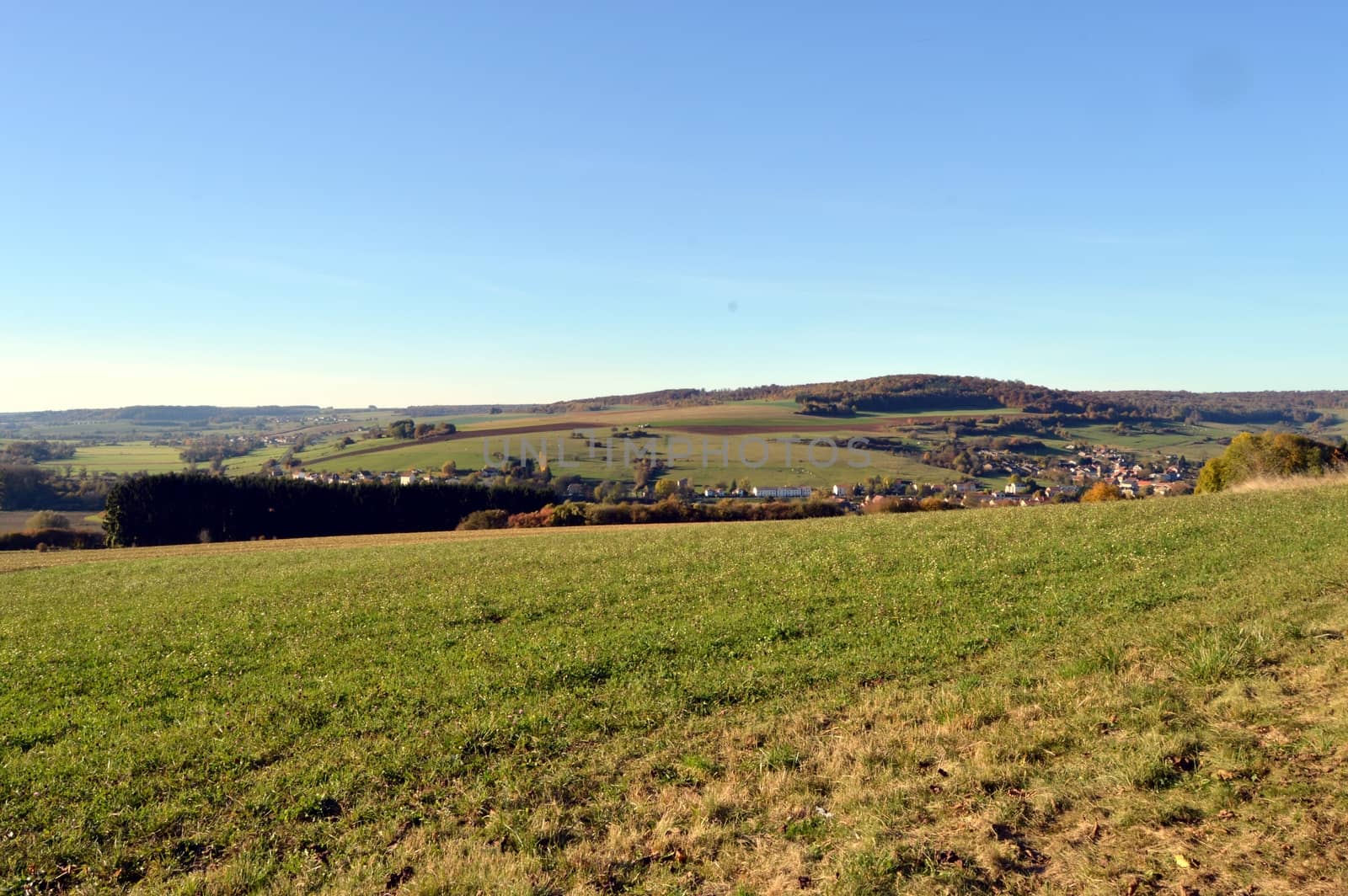 Plow fields with a background hill and a village