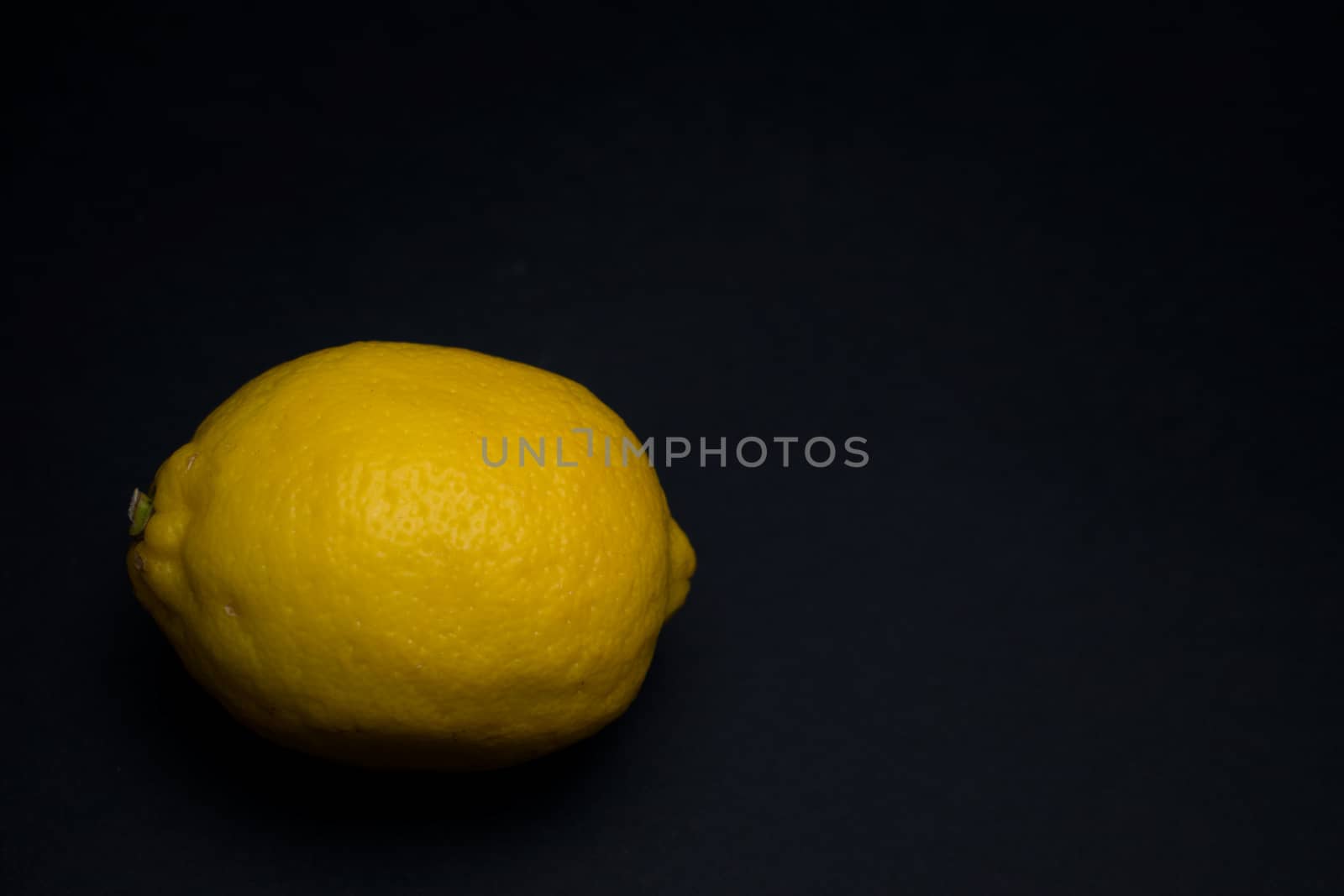 Raw entirre isolated lemon on a dark background