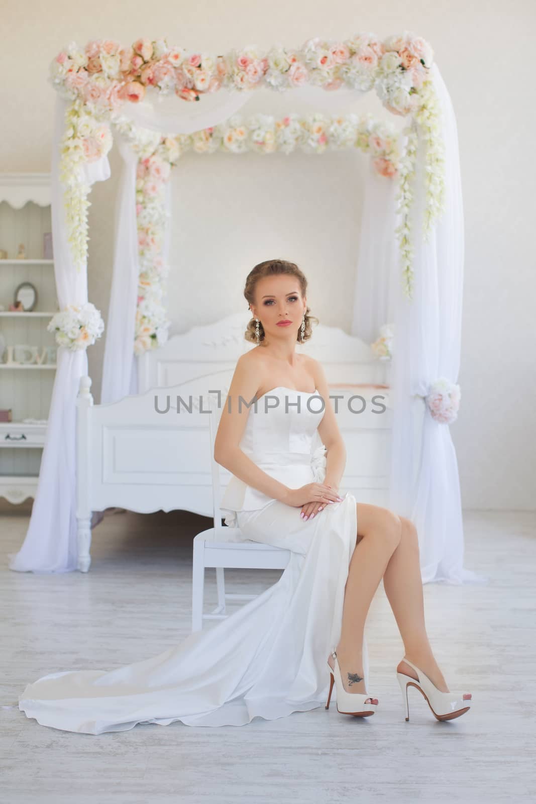 The bride in a long white dress in the room
